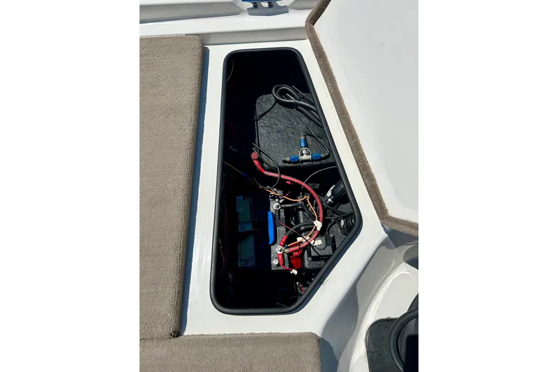 Slide: The Image of Open storage compartment in a 2006 Ranger 180 Reata boat, showing wiring and equipment. - 42
