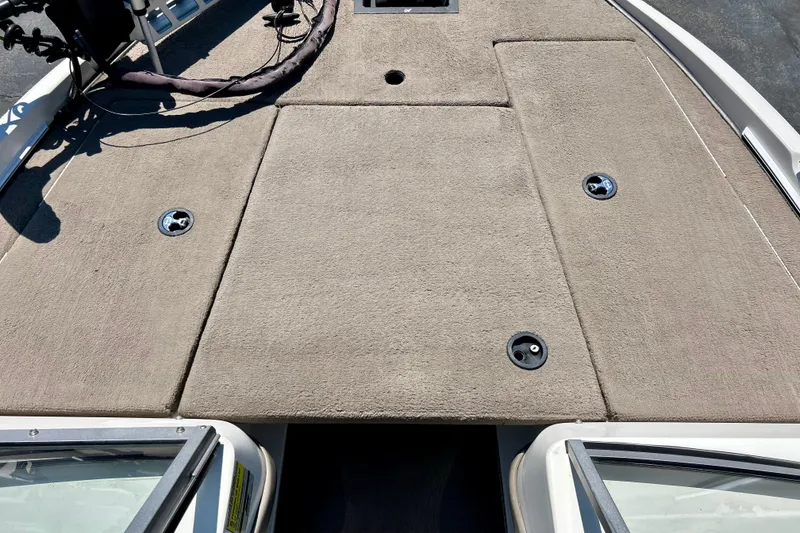 Slide: The Image of 2006 Ranger 180 Reata boat deck with beige carpet and storage compartments. - 56