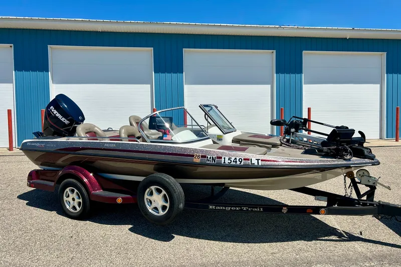 Slide: The Image of 2006 Ranger 180 Reata boat on trailer, parked outside blue building. - 4