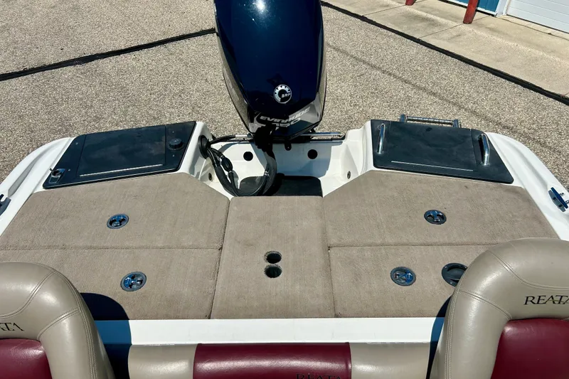 Slide: The Image of 2006 Ranger 180 Reata boat with Evinrude motor, featuring beige seating and storage compartments. - 38