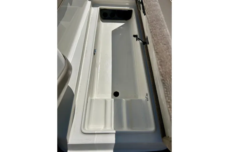 Slide: The Image of 2006 Ranger 180 Reata boat storage compartment, open and empty, with carpeted edge. - 29