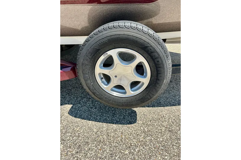 Slide: The Image of Trailer wheel of a 2006 Ranger 180 Reata boat on asphalt surface. - 8