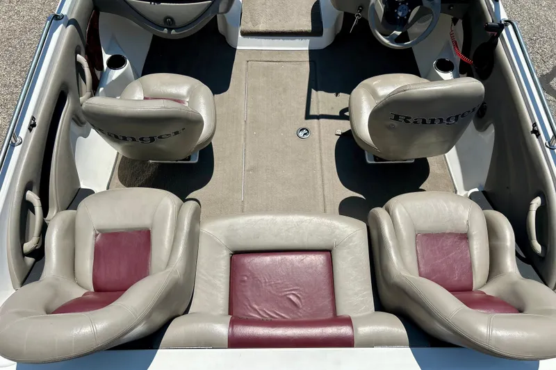 Slide: The Image of 2006 Ranger 180 Reata boat interior with beige and maroon seating, steering wheel visible. - 47