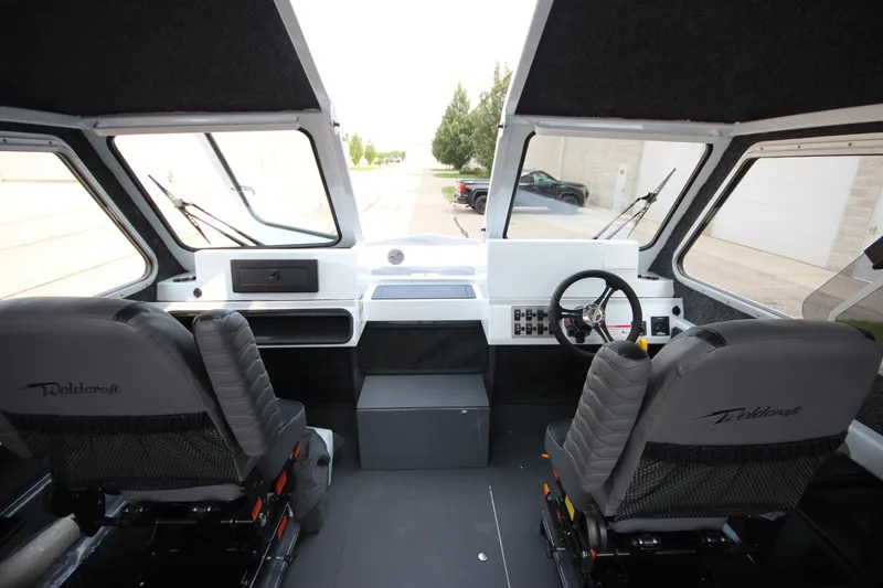 Slide: The Image of Interior view of 2027 Weldcraft 240 Maverick DV boat cockpit with dual seats and steering wheel. - 21