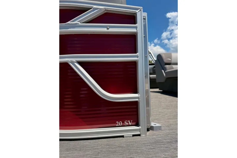 Slide: The Image of 2024 Bennington SV 20 pontoon boat with red paneling and silver trim under a blue sky. - 10