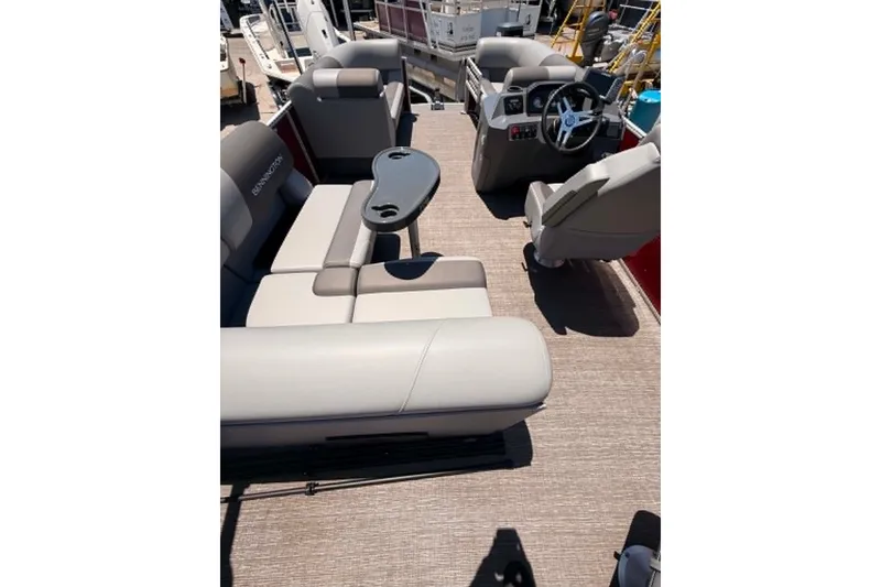 Slide: The Image of 2024 Bennington SV 20 pontoon boat interior with plush seating and steering console. - 2