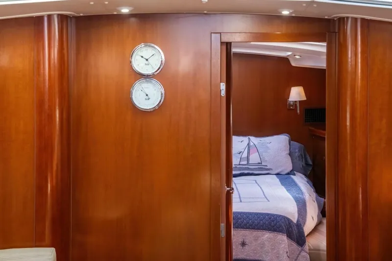 Slide: The Image of Interior of 2007 Beneteau Oceanis Clipper 523 with nautical-themed bedding and wooden finish. - 16