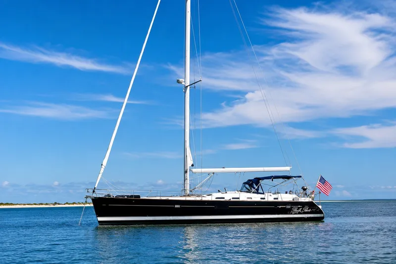 The Image of 2007 Beneteau Oceanis Clipper 523 sailboat on calm water under a clear blue sky. - 0