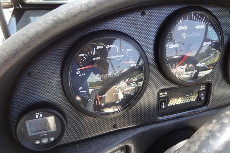 Slide: The Image of Dashboard of a 2000 Malibu Sunsetter VLX boat with gauges and controls. - 21