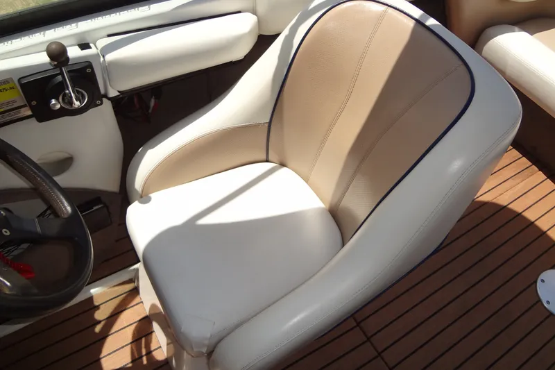Slide: The Image of Captain's seat in 2000 Malibu Sunsetter VLX boat, featuring beige and white upholstery. - 19