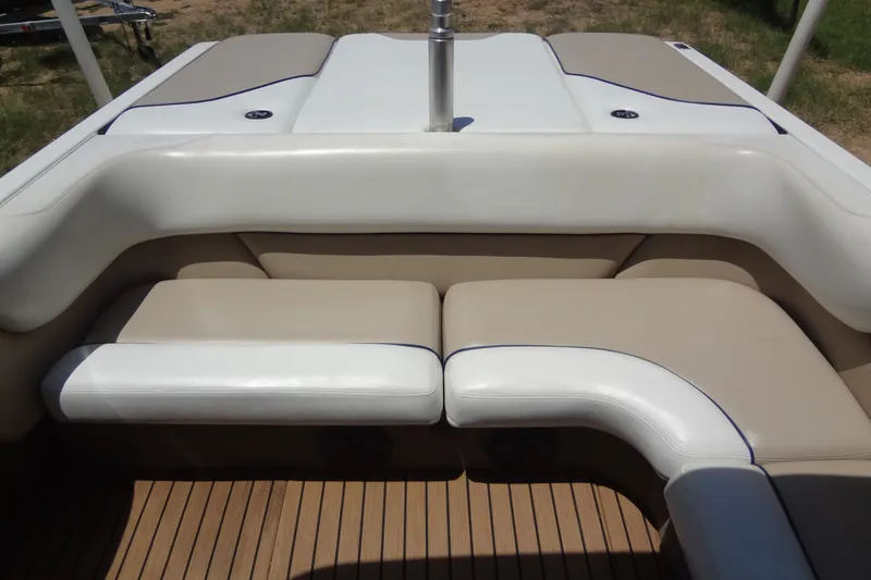 Slide: The Image of 2000 Malibu Sunsetter VLX boat interior with beige and white seating on wooden deck. - 18