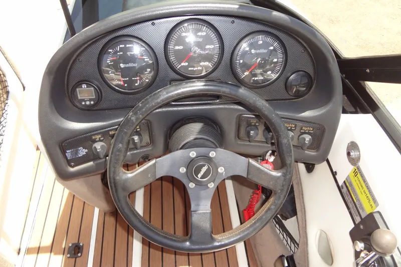 Slide: The Image of Dashboard of a 2000 Malibu Sunsetter VLX boat with steering wheel and gauges. - 20