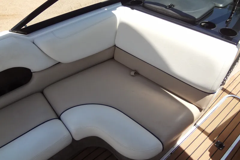 Slide: The Image of Interior seating of a 2000 Malibu Sunsetter VLX boat with beige upholstery. - 16