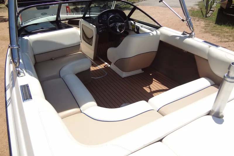Slide: The Image of Interior of a 2000 Malibu Sunsetter VLX boat with beige seating and wooden flooring. - 15
