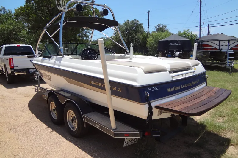 Slide: The Image of 2000 Malibu Sunsetter VLX boat on trailer, parked outdoors, with a white truck nearby. - 5