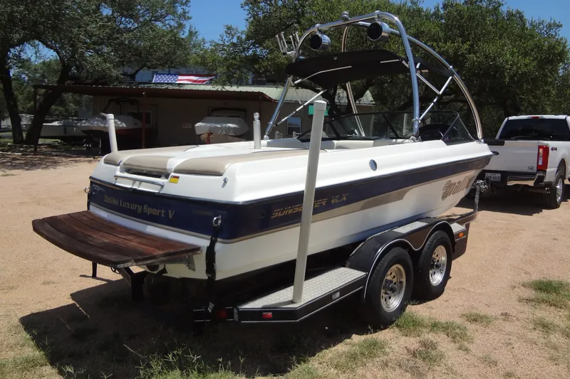 Slide: The Image of 2000 Malibu Sunsetter VLX boat on trailer, parked outdoors near trees. - 2