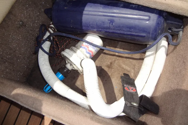 Slide: The Image of Storage compartment in a 2000 Malibu Sunsetter VLX boat with hoses and equipment. - 28