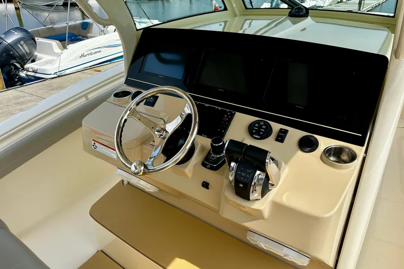Slide: The Image of 2019 Scout 355 LXF boat helm with steering wheel and control panel. - 8