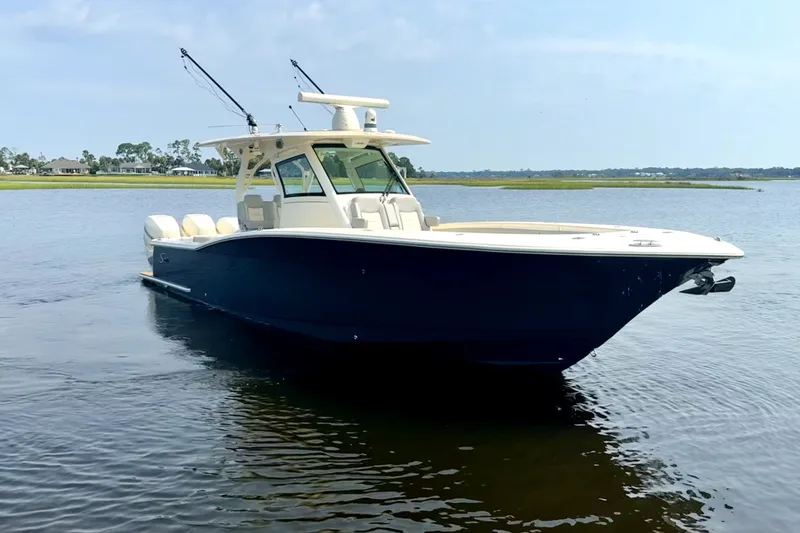 Slide: The Image of 2019 Scout 355 LXF boat on calm water, showcasing sleek design and luxury features. - 3