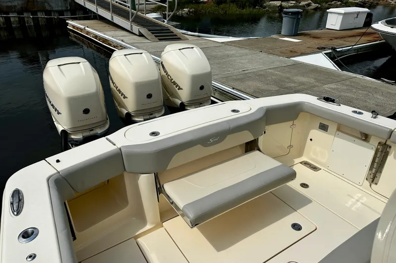 Slide: The Image of 2019 Scout 355 LXF boat with triple Mercury engines docked at marina. - 14