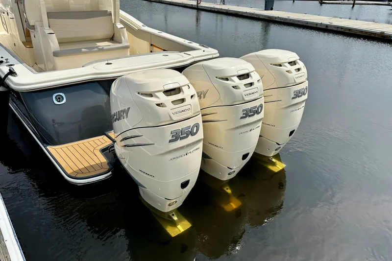 Slide: The Image of 2019 Scout 355 LXF boat with triple Mercury 350 Verado engines docked. - 28