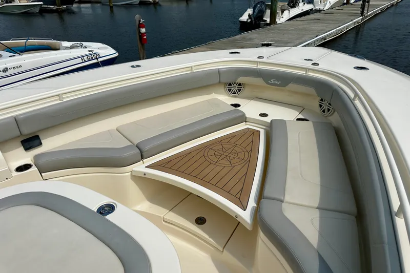 Slide: The Image of Luxurious 2019 Scout 355 LXF boat interior with elegant seating and wooden accents at a marina. - 21