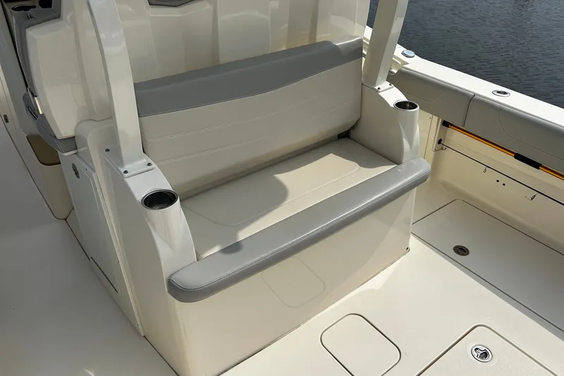 Slide: The Image of 2019 Scout 355 LXF boat seating area with cup holders, on calm water. - 12