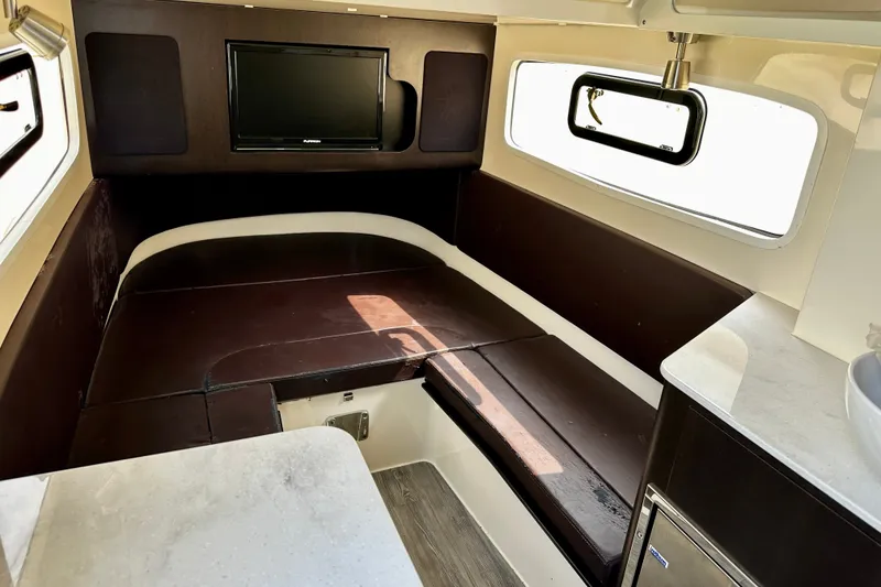 Slide: The Image of 2019 Scout 355 LXF cabin interior with seating, TV, and window view. - 24