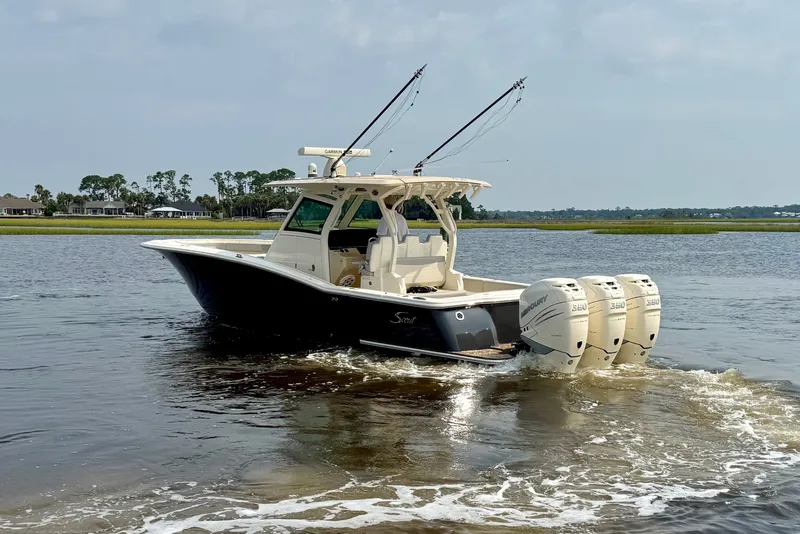 Slide: The Image of 2019 Scout 355 LXF boat with triple Mercury engines on a calm waterway. - 7