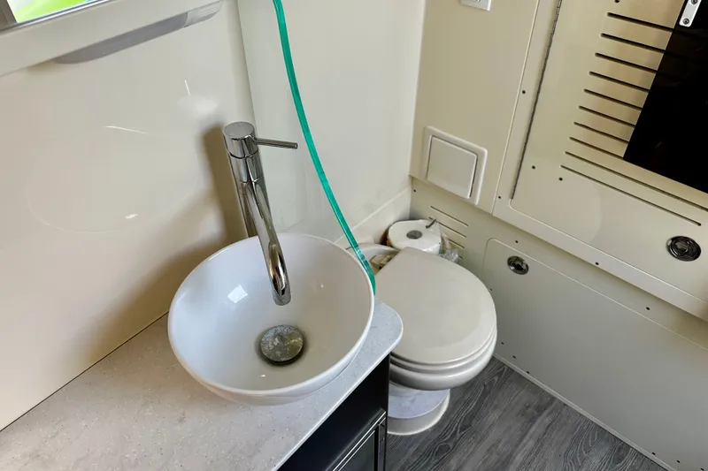 Slide: The Image of 2019 Scout 355 LXF boat bathroom with modern sink and toilet. - 23