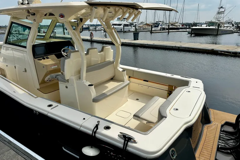 Slide: The Image of 2019 Scout 355 LXF boat docked at marina, showcasing spacious seating and helm area. - 26