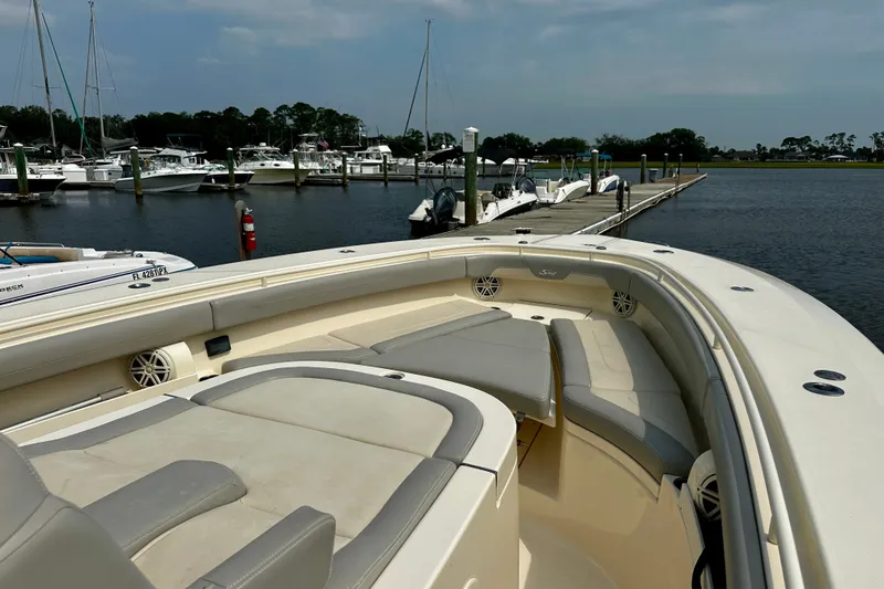 Slide: The Image of 2019 Scout 355 LXF boat docked at marina, featuring spacious seating and sleek design. - 20