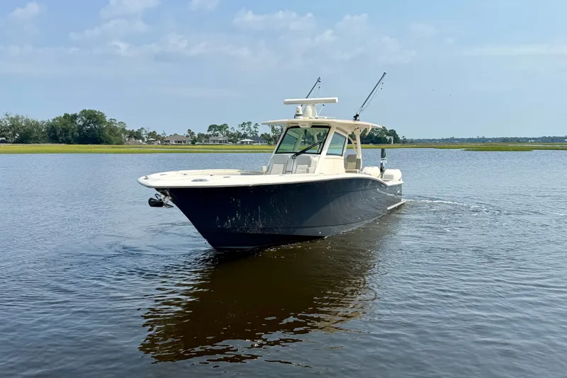 Slide: The Image of 2019 Scout 355 LXF boat cruising on calm water under a clear sky. - 1