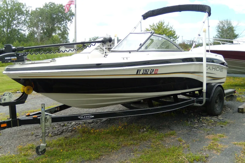 Slide: The Image of 2008 Tahoe Q4 SF boat on trailer with Minn Kota motor, parked outdoors. - 1