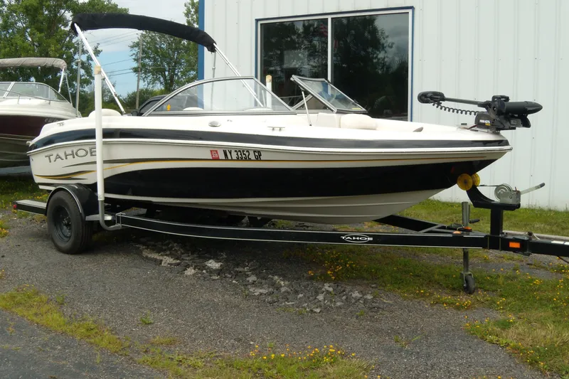 Slide: The Image of 2008 Tahoe Q4 SF boat on trailer, parked outdoors near a building. - 0
