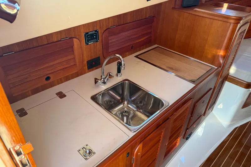 Slide: The Image of Hinckley Picnic Boat 36 Classic 2000 galley with wooden cabinetry and stainless steel sink. - 15