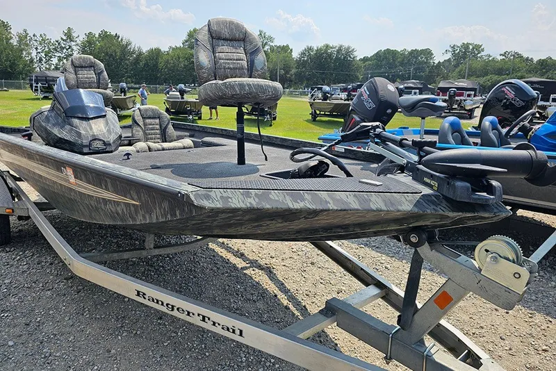 Slide: The Image of 2020 Ranger RT178 fishing boat on trailer, featuring camo seats and motor, parked outdoors. - 6