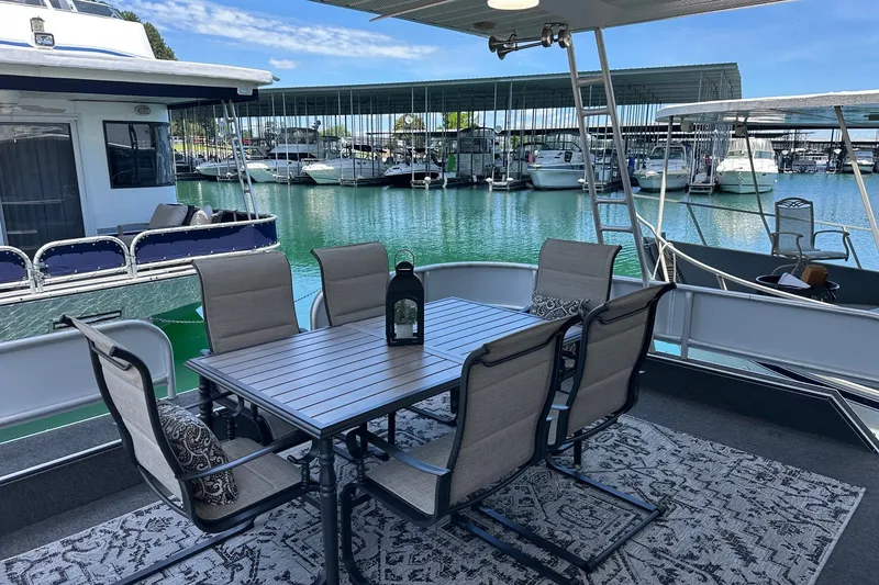 Slide: The Image of Outdoor dining area on a 1993 Sumerset 14x65 houseboat, docked at a marina. - 1