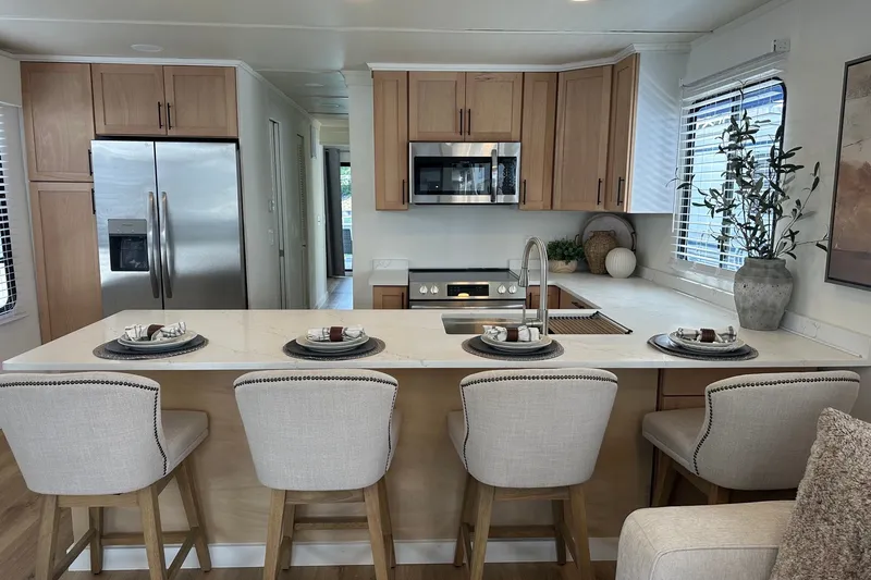 Slide: The Image of Modern kitchen interior in a 1993 Sumerset 14x65 houseboat, featuring a sleek countertop and bar stools. - 5