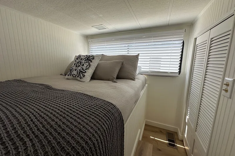 Slide: The Image of Cozy bedroom in 1993 Sumerset 14x65 houseboat with plush bedding and natural light. - 7