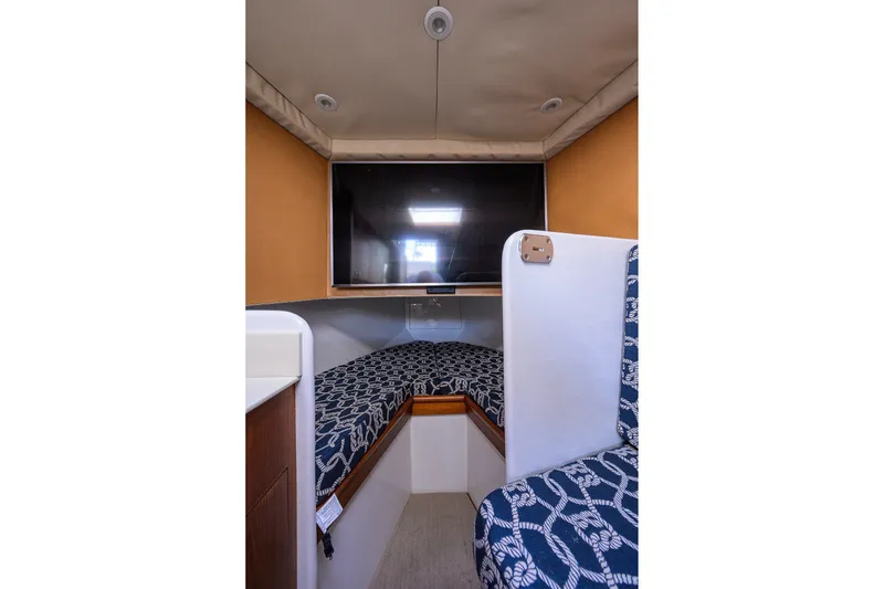 Slide: The Image of Interior of 2014 Release Boatworks 46, featuring a cozy cabin with patterned seating. - 50
