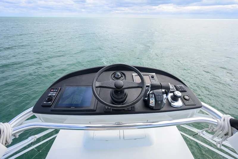 Slide: The Image of Helm of 2014 Release Boatworks 46, featuring modern navigation controls on open water. - 40