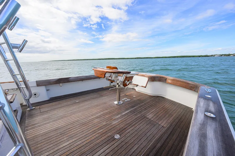 Slide: The Image of 2014 Release Boatworks 46 with wooden deck, ocean view, and clear blue sky. - 23