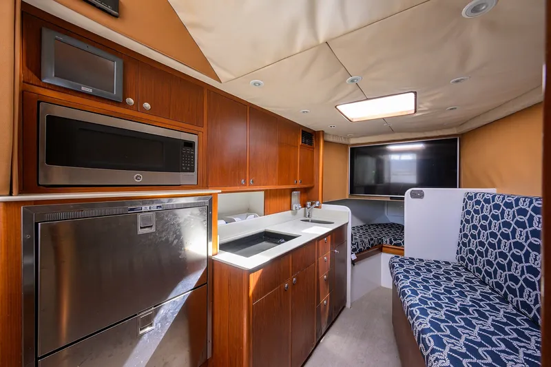 Slide: The Image of Interior of 2014 Release Boatworks 46 with kitchen, seating, and TV. - 44