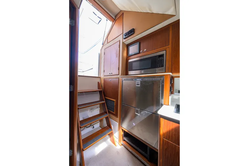 Slide: The Image of Interior of 2014 Release Boatworks 46, featuring wooden cabinetry, stairs, and modern appliances. - 42