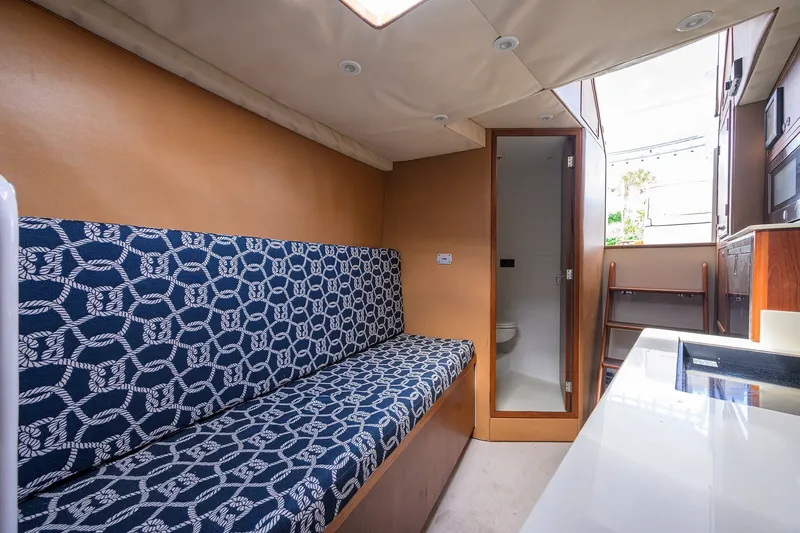 Slide: The Image of Interior of 2014 Release Boatworks 46, featuring patterned seating and compact bathroom. - 47