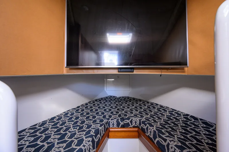 Slide: The Image of Interior cabin of 2014 Release Boatworks 46 with patterned bedding and mounted TV. - 51