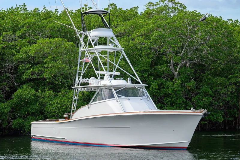 Slide: The Image of 2014 Release Boatworks 46 yacht in serene waters, surrounded by lush greenery. - 5