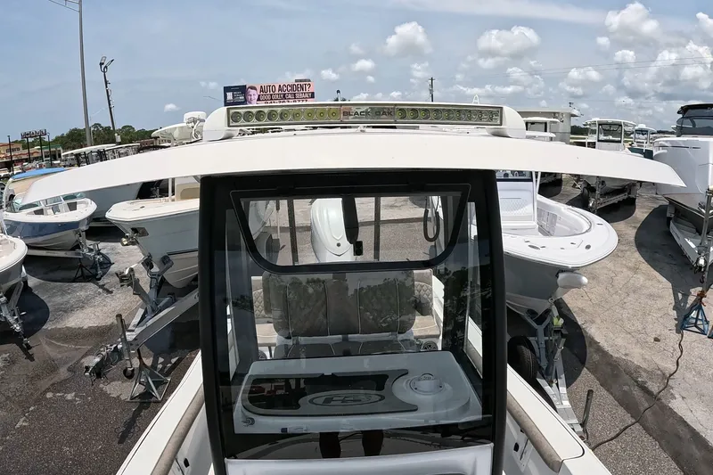 Slide: The Image of 2026 Seahunt BX25FS boat displayed in a marina with other vessels under a clear sky. - 12