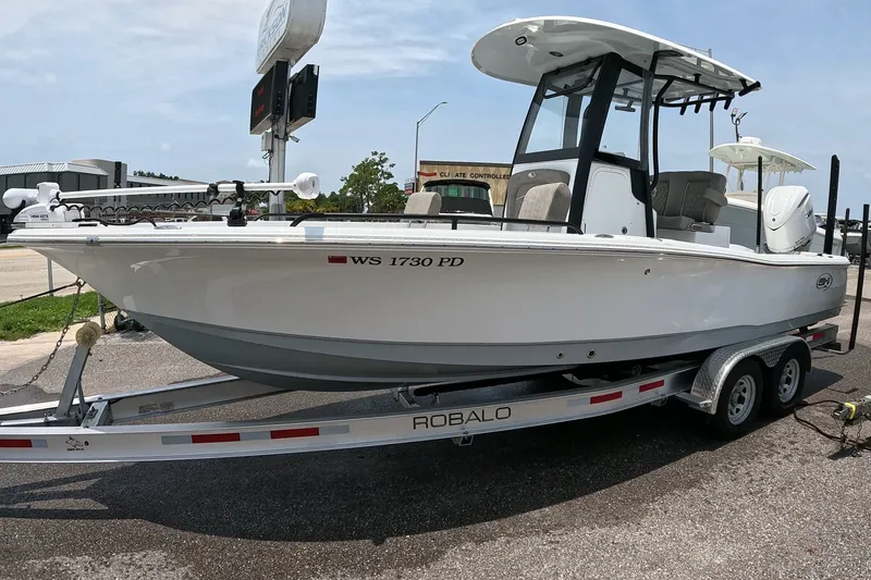 Slide: The Image of 2026 Seahunt BX25FS boat on Robalo trailer, parked outdoors. - 4